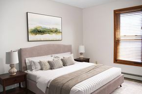 La Crosse apartment for rent - A bedroom with a large bed and a painting on the wall.