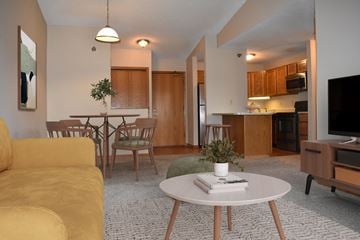 Hopkins apartment for rent - A living room with a yellow couch and a white coffee table.
