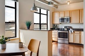 Minneapolis apartment for rent - Kitchen with wood cupboards and a dining table in the foreground