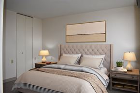 St. Paul apartment for rent - A bedroom with a large bed and two lamps on side tables.