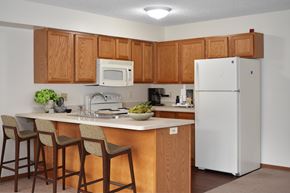 Plymouth apartment for rent - A kitchen with a white refrigerator and wooden cabinets.