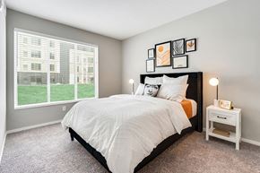 Bloomington apartment for rent - a bedroom with a large window and a bed