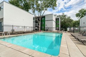 Hopkins apartment for rent - A swimming pool in front of a building with a green door.