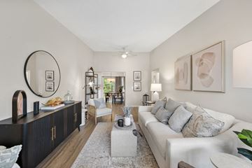 Mentor apartment for rent - A living room with a white couch and a large mirror on the wall.