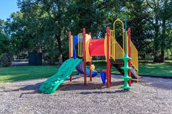 A playground with a slide and other toys in a park 