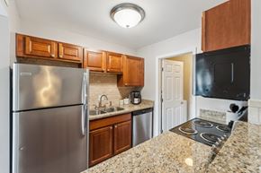 Charleston apartment for rent - A kitchen with granite countertops and stainless steel appliances. at Sawgrass Apartments, South Carolina
