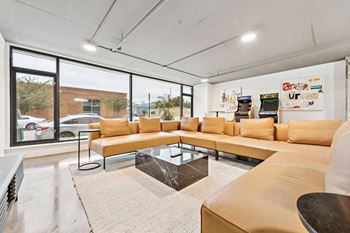 A modern living room with a large sectional sofa and a coffee table in front of a large window
