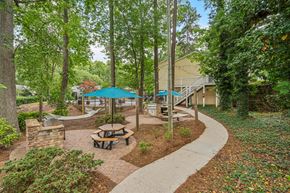 Raleigh apartment for rent - a picnic area with benches and umbrellas in a park at Clarion Crossing Apartments, PRG Real Estate Management, Raleigh