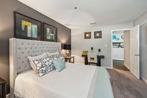 Richmond apartment for rent - A bedroom with a large bed and a white headboard. at The Timbers Apartments, Richmond