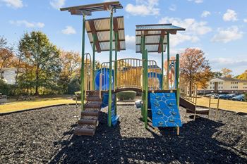 A playground with a blue slide and a brown wooden structure