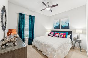 Charleston apartment for rent - A bedroom with a white bed and a ceiling fan at Proximity Apartments, South Carolina, 29414