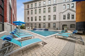 A pool with blue loungers and a waterfall feature