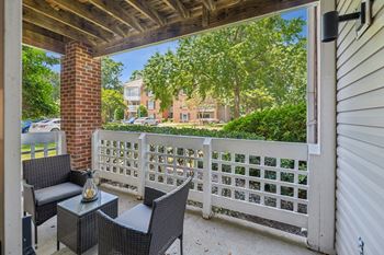 A patio with a white fence and a brick pillar.