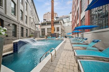 A pool with a waterfall and lounge chairs