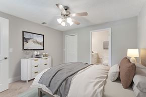 Winter Garden apartment for rent - a bedroom with a bed and a ceiling fan at Palm Crossing Apartments in Winter Garden, FL