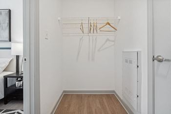 A bedroom with a white walls and a wooden floor