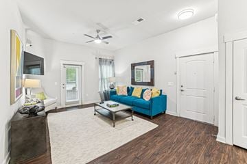 Charleston apartment for rent - A living room with a blue couch and a ceiling fan.