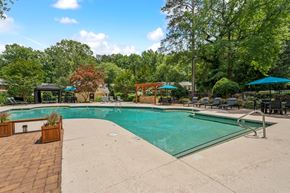 Raleigh apartment for rent - a swimming pool with trees in the background and a resort style pool at Clarion Crossing Apartments, PRG Real Estate Management, Raleigh