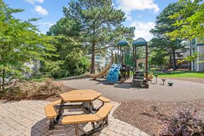 Raleigh apartment for rent - a playground with a slide and picnic tables at The Falls Apartments in Raleigh NC