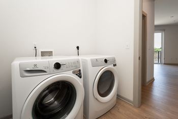 Two white front load washing machines in a laundry room