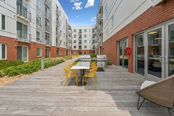 A patio with a table and chairs is surrounded by apartment buildings