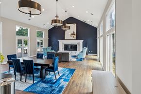 Richmond apartment for rent - A modern dining room with a fireplace and blue chairs. at The Timbers Apartments, Richmond 23235