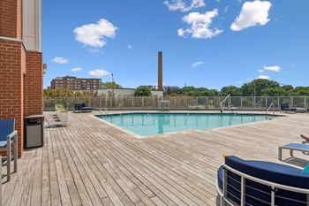 A wooden deck with a pool and a blue couch