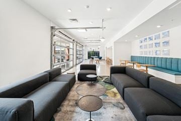 Norfolk apartment for rent - A modern living room with black sofas and a glass wall.