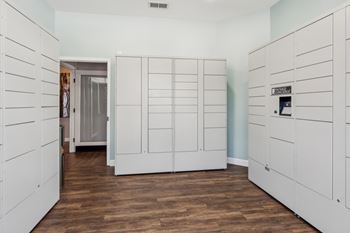 A room with white cupboards and wooden floors.