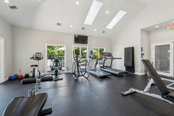 A spacious gym with a variety of equipment including treadmills, exercise bikes, and weight machines.