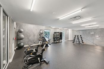A gym with exercise equipment and a mirror on the wall.