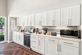 Cary apartment for rent - A kitchen with white cabinets and a wood floor. at Woodcreek Apartments, Cary, NC, 27511