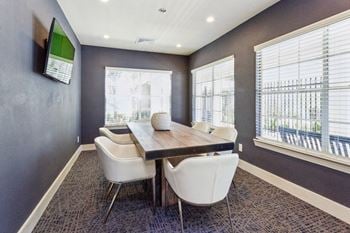 A conference room with a table and chairs and a tv