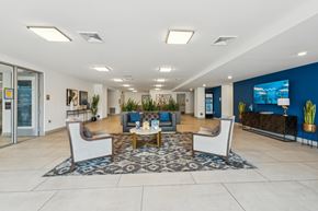 Richmond apartment for rent - A spacious lobby with a blue accent wall and a large screen TV  at The Waterford At Rocketts Landing Apartments, PRG Real Estate, Richmond, Virginia