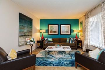 Cary apartment for rent - A living room with a brown leather couch, a coffee table, and a painting on the wall.