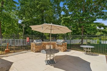 A patio with a table and chairs under an umbrella.