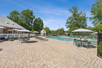 A large outdoor patio with a pool and umbrellas.
