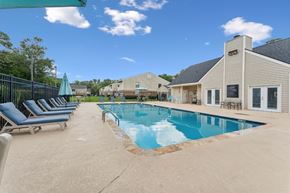 Charleston apartment for rent - A pool with a blue umbrella and lounge chairs at Sawgrass Apartments, Charleston 29412