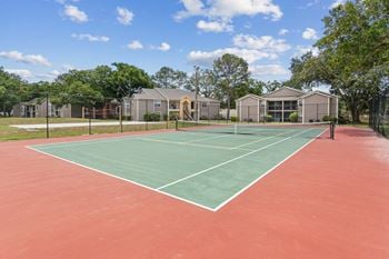 A tennis court with apartments in the background