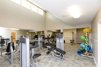 A gym with a variety of equipment including weights and machines