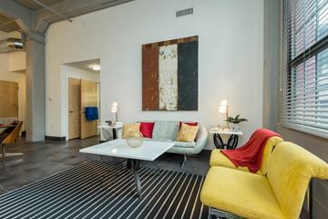 Richmond apartment for rent - A living room with a yellow couch and a white coffee table.