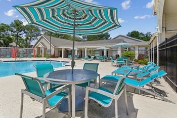 Our apartments have a pool and patio with chairs and umbrellas
