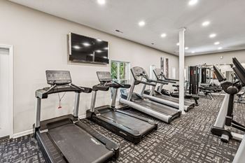 A gym with treadmills and other exercise equipment.