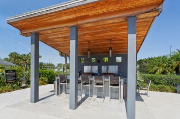 A patio with a bar and chairs under a wooden roof