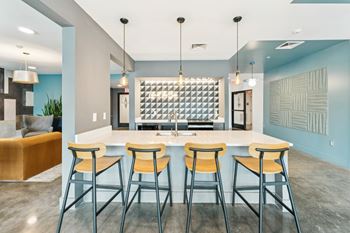 A modern kitchen with a bar area and stools