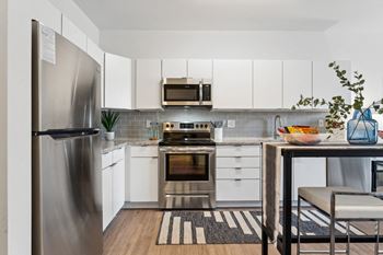 A kitchen with white cabinetry and stainless steel appliances