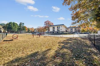 A park with a playground and a building in the background