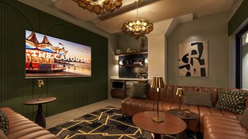 A living room with a brown leather couch and a large screen displaying