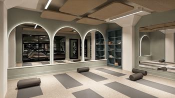 A yoga studio with grey mats on the floor