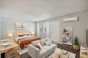 Raleigh apartment for rent - A well-lit bedroom with a bed, couch, and a dining table at Clarion Crossing Apartments, PRG Real Estate Management, Raleigh